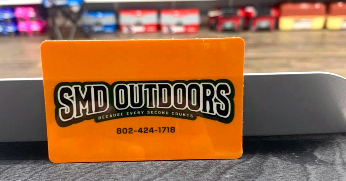 Orange gift card with SMD Outdoors logo on counter
